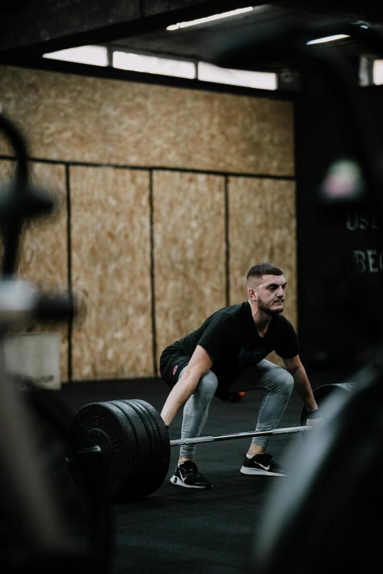 A determined man weightlifting in a gym, showcasing strength and endurance during training.